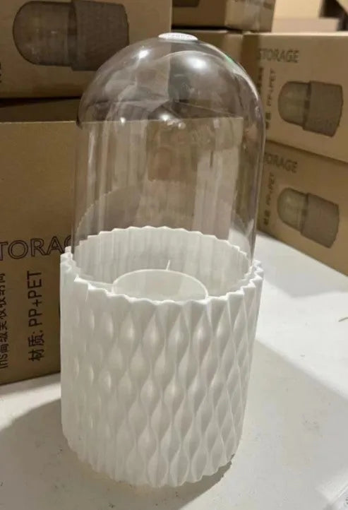 White acrylic rotating makeup brush holder with transparent dust cover on desktop