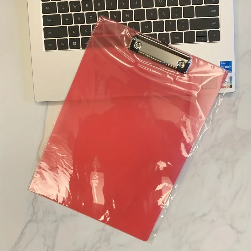 Transparent A4 plate holder with metal clip in blue, holding white paper, on a wooden desk.