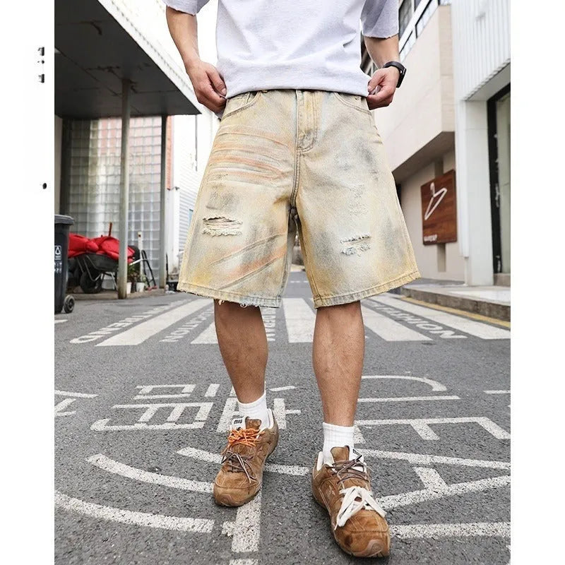 Light blue ripped denim shorts for men on a mid-thigh model, showing straight-leg cut and distressed details.