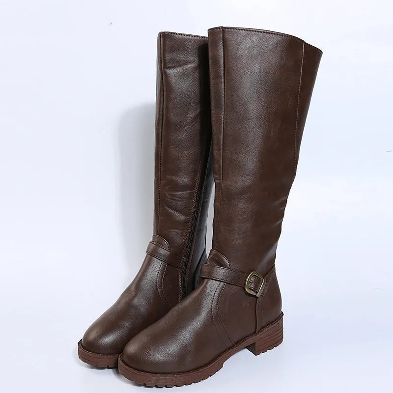 Women's black knight boots with belt buckle details and square heel on model