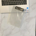 Transparent A4 plate holder with metal clip in blue, holding white paper, on a wooden desk.