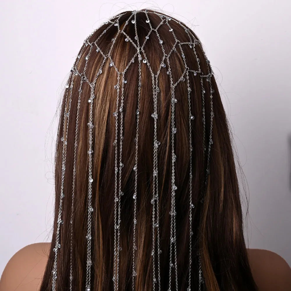 Gold rhinestone mesh headband with a tassel detail on a model's hair.