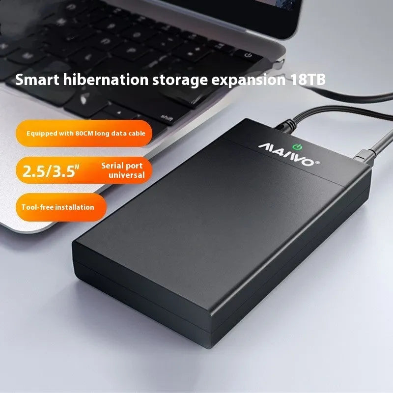 Black and silver 3.5 inch USB SATA hard drive enclosure with power supply and cable on a desk.