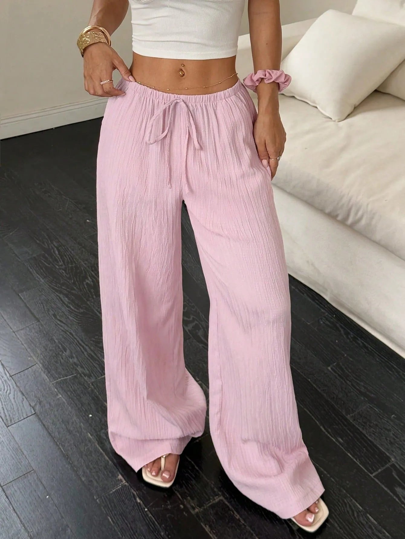 Women's black wide leg trousers with lace-up waist trimming showing adjustable detail