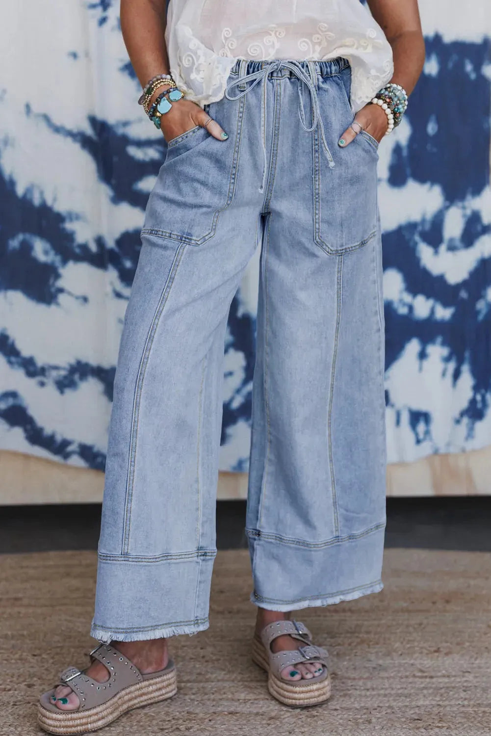 Beau blue women's wide-leg denim jeans with drawstring waist detailing and raw unfinished hem.