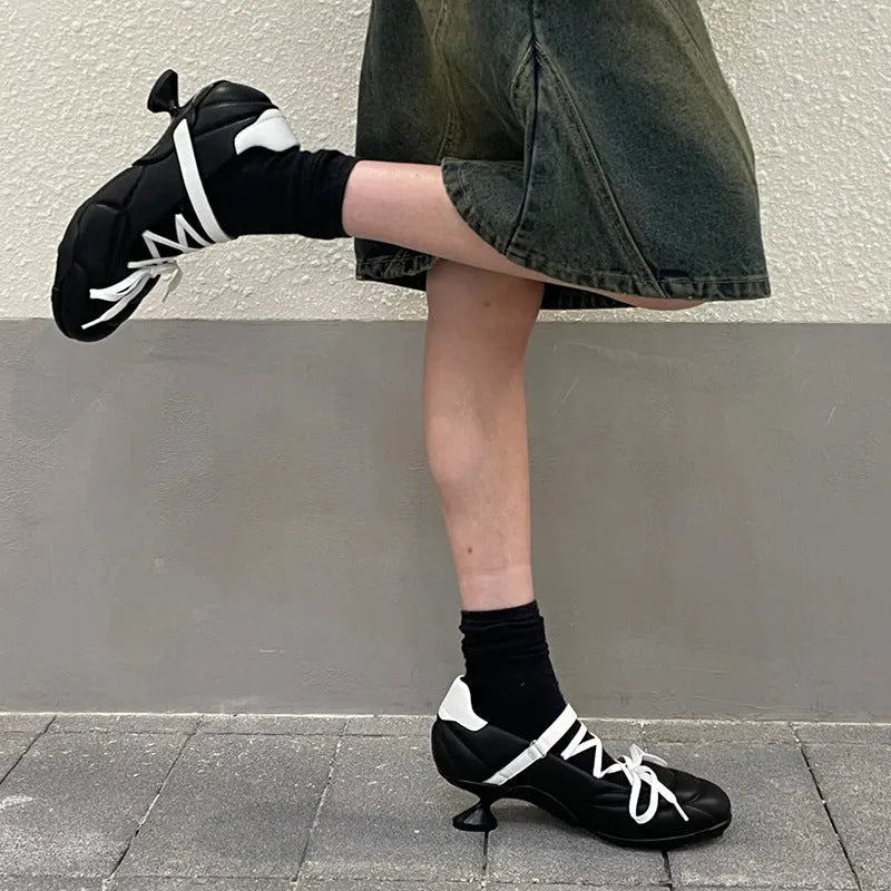 Women's silver sports shoes with a front lace-up bow and a mid heel on a white background.