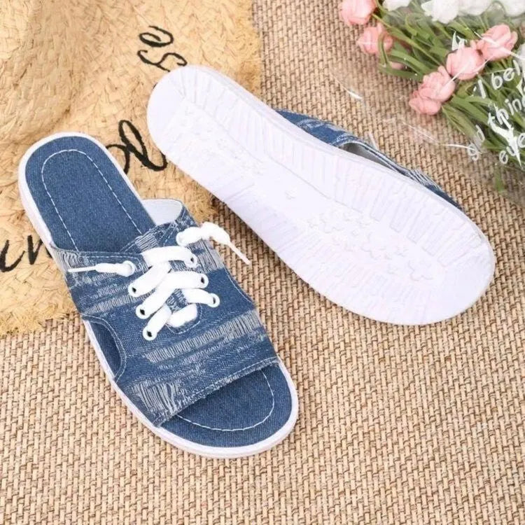 Blue Roman style women's flat canvas slippers with cloth lining, shown from the side.