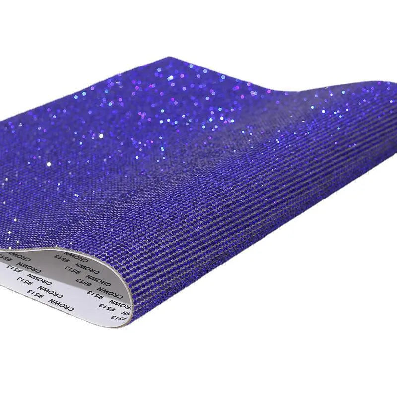 Hot-fix rhinestone transfer sheet on a roll showing sparkling electroplated stones in multiple colours on adhesive backing.