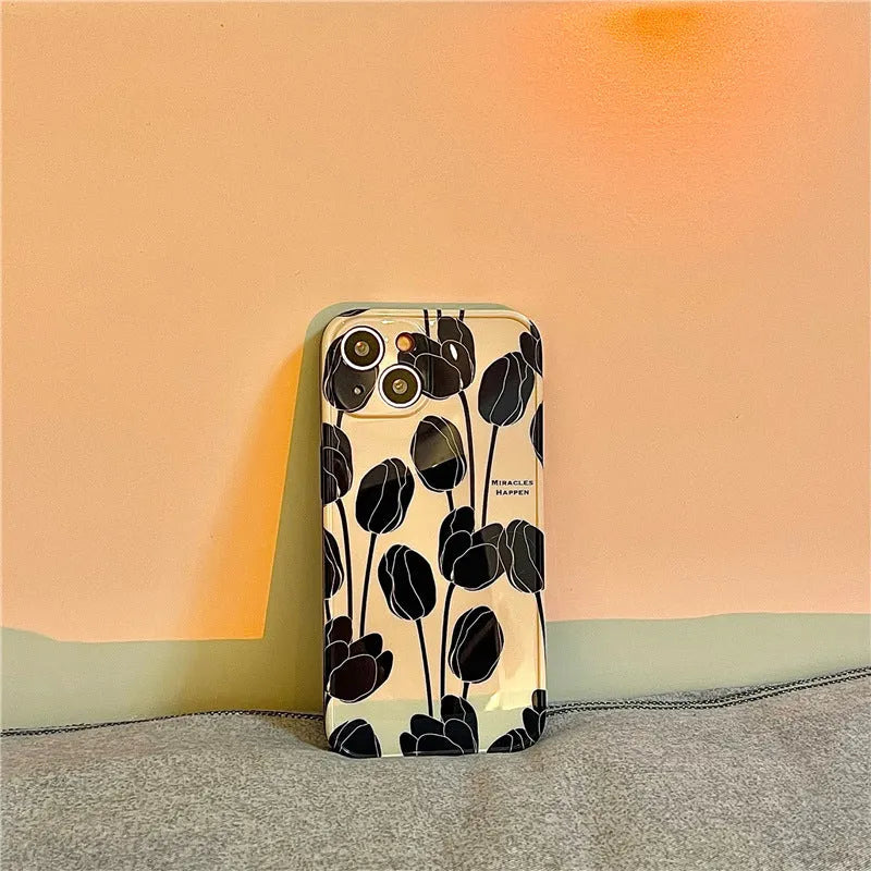 Black silicone iPhone case with a detailed white tulip pattern on the back.