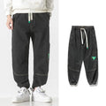 Men's loose-fit tapered cotton trousers in black, available in sizes from M to 8XL