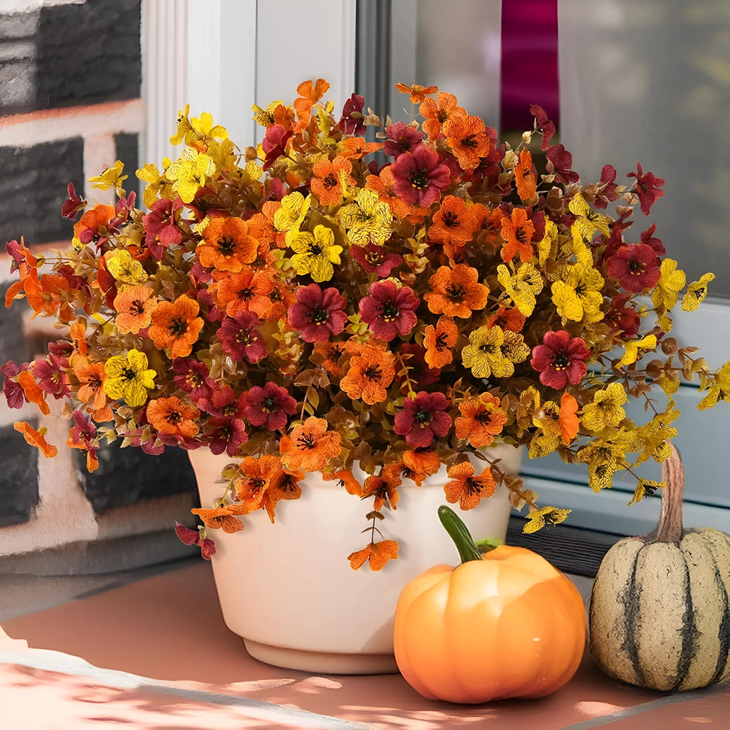 Artificial flower bouquet in autumn colours including orange, yellow, and red tones