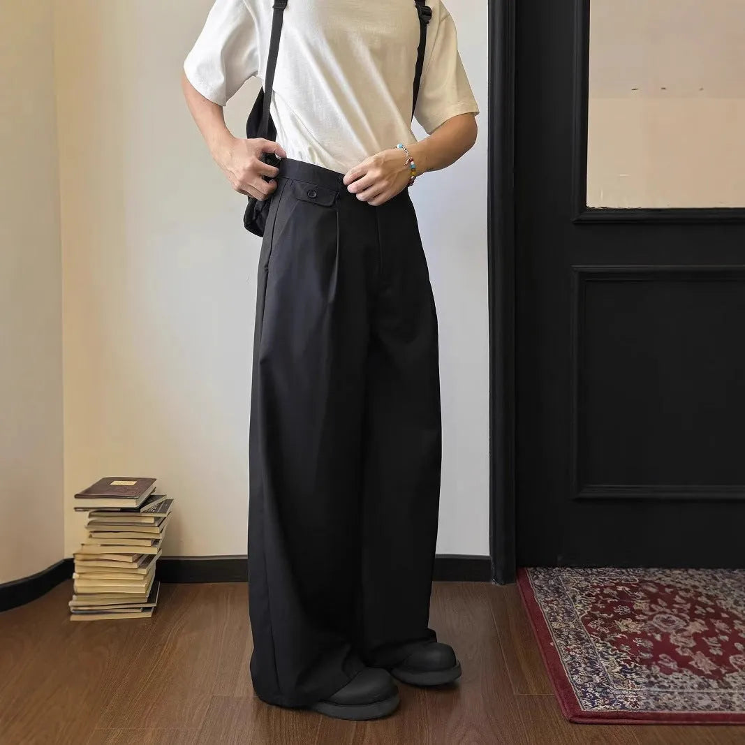 Men's straight-leg wide trousers in black, showing casual suit pant style with draping fabric.