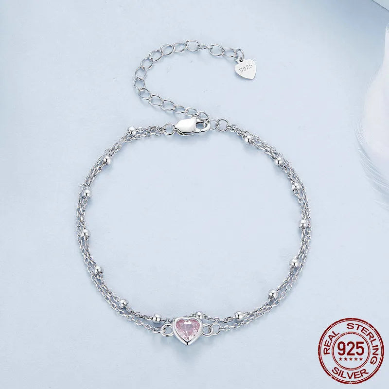 Women's sterling silver bracelet with a small heart-shaped charm on an adjustable chain.