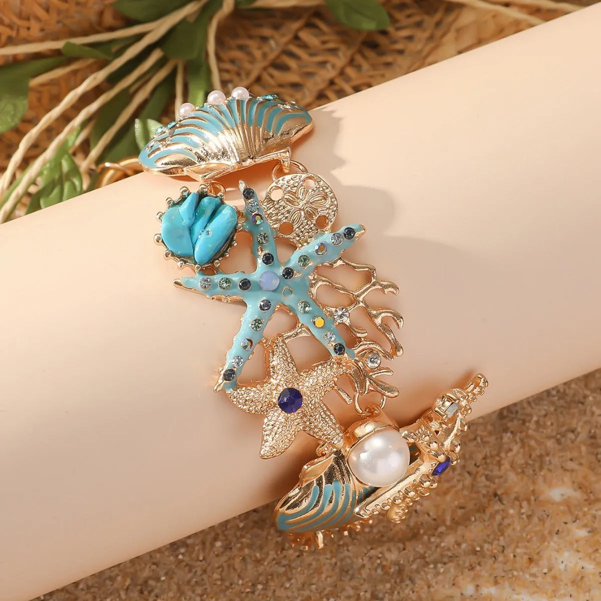Women's alloy bracelet with starfish and boat anchor rhinestones in turquoise, red, or blue.