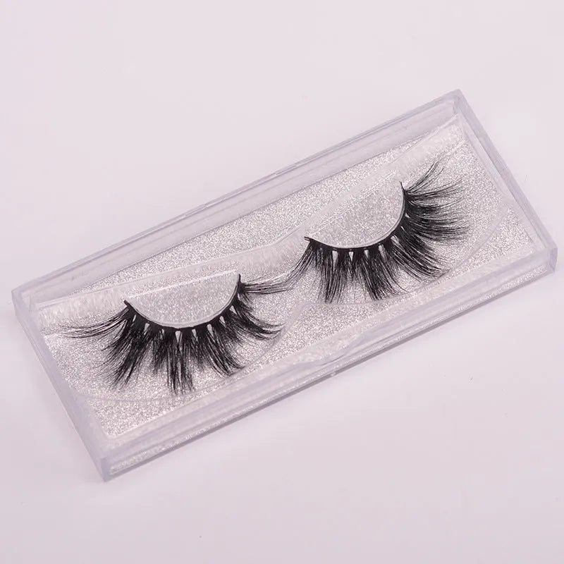 5D Mink False Eyelashes set with hair cap and double-headed brush on a pink background.