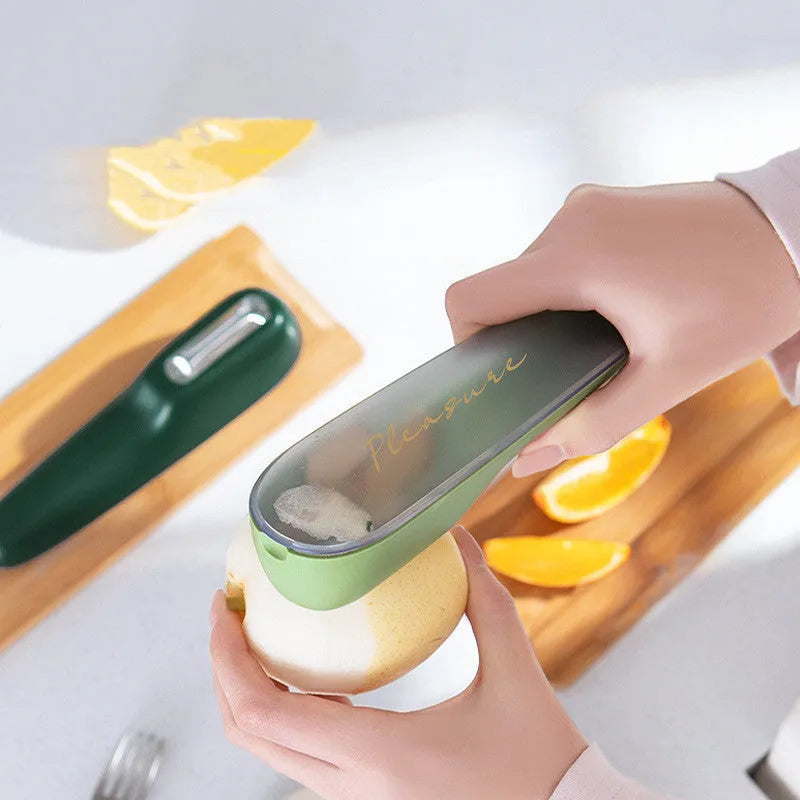 Dark green vegetable peeler with storage tube, showing stainless steel blade and non-slip handle.