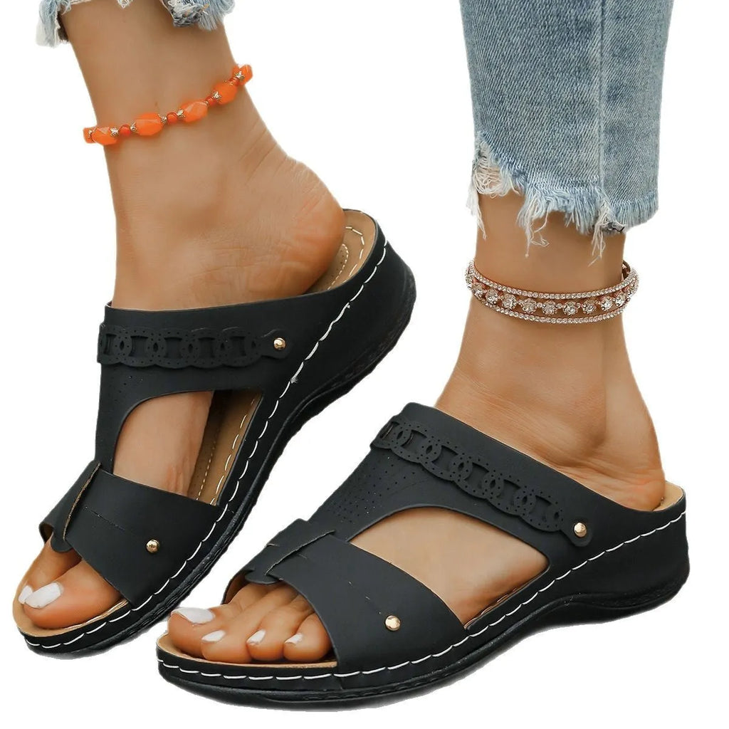 Blue casual slippers with a fish mouth toe holder and slope heel on a wooden floor.