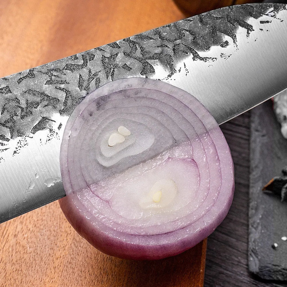 Handmade hammered forged stainless steel santoku chef knife with gift box packaging on a kitchen surface