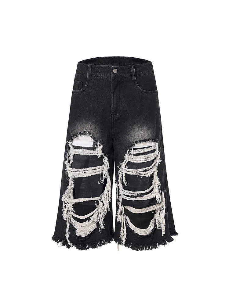 Black wide leg cropped jeans with mid-high waist and ripped patch detail on the legs.