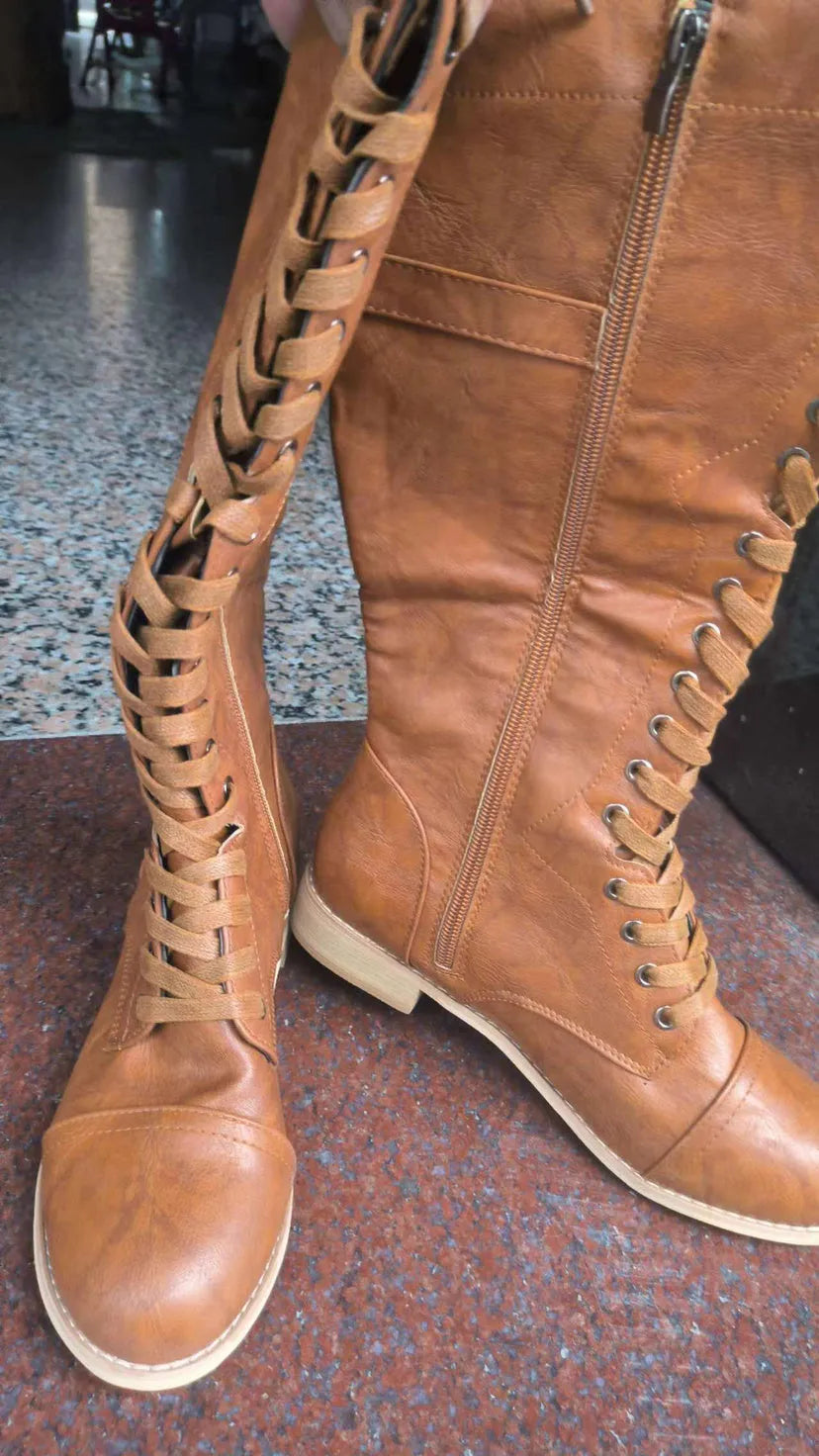 Women's black knight boots with cross-strap design across ankle, mid heel