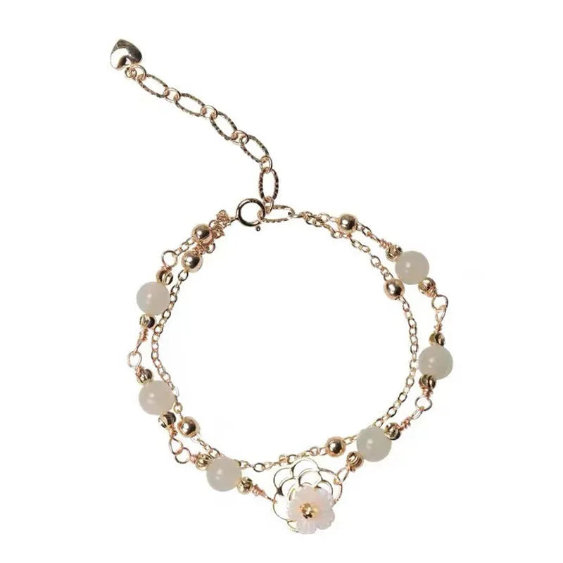 Electroplated copper butterfly bracelet with geometric design and yellow gold finish, showing floral shell motif