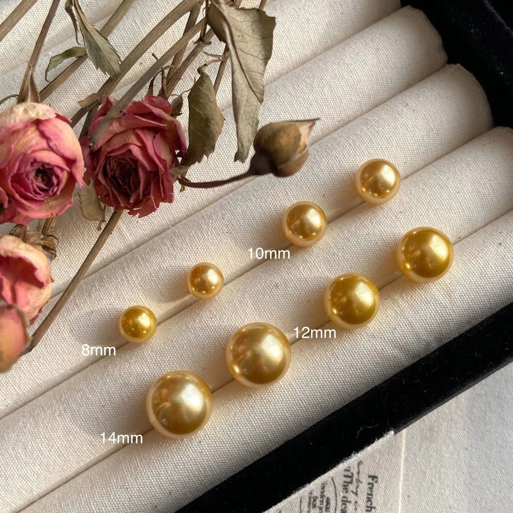 Large pearl stud earrings in geometric shape with eight awn star detail and pearl accents on silver background