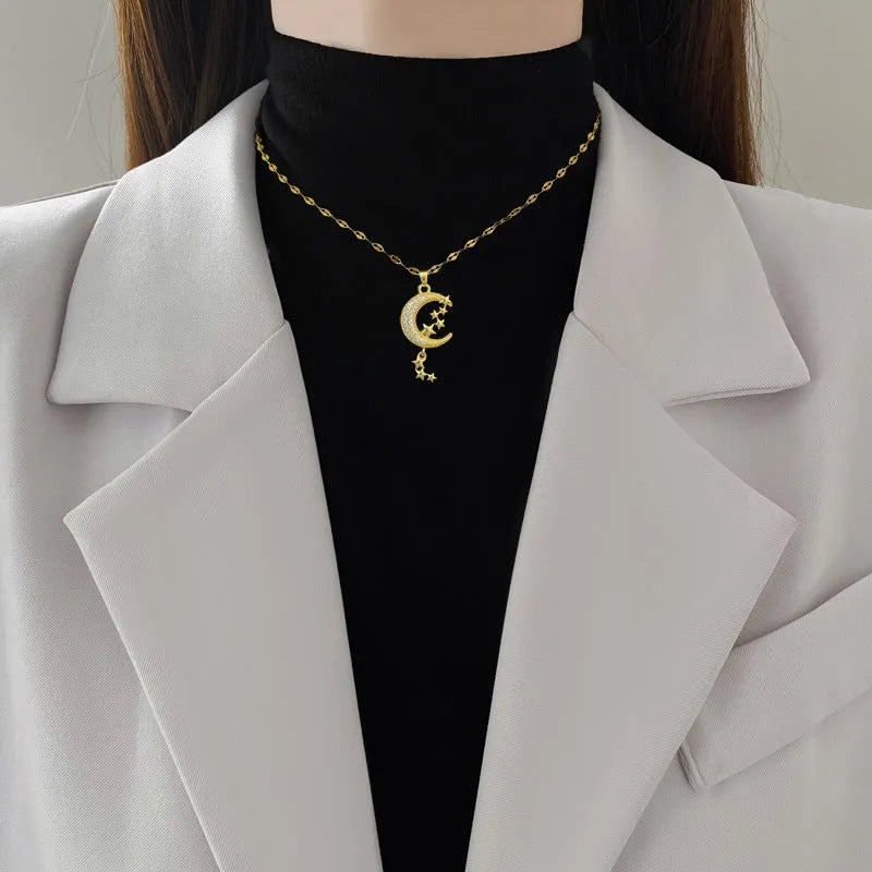 Moon pendant necklace with tassel design and diamond accents on stainless steel chain