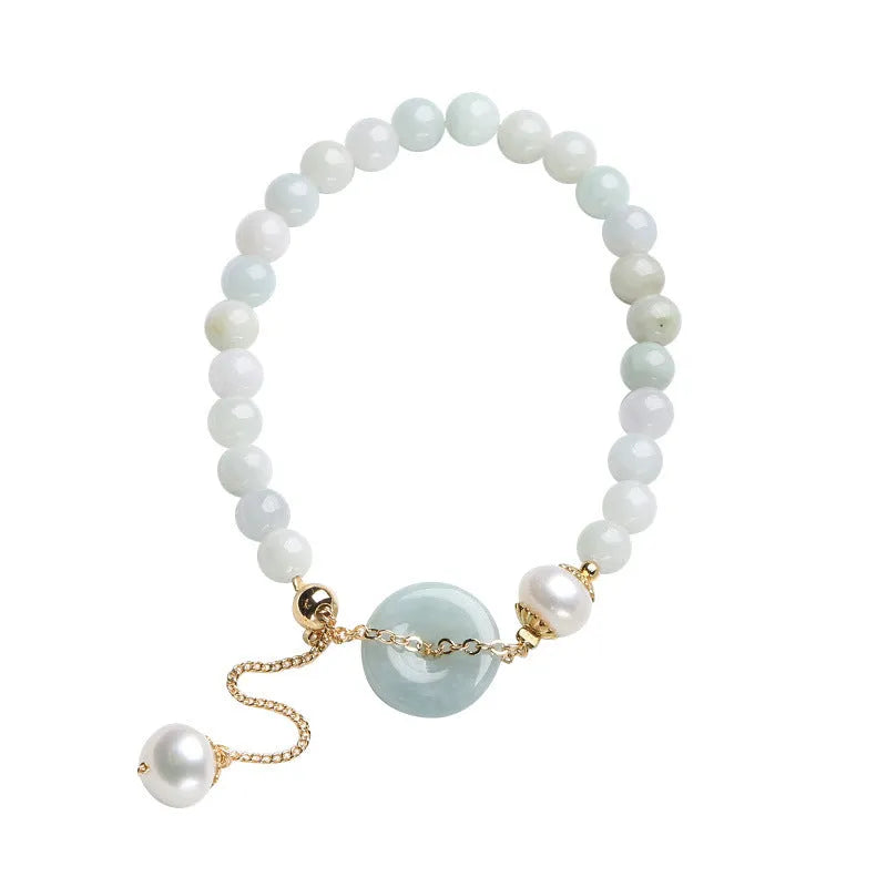 Natural emerald green jade and pearl bracelet with a geometric peace buckle clasp.