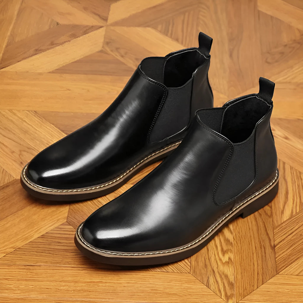 Men's black formal pointed-toe leather boots with a square heel and rubber sole on a plain background.