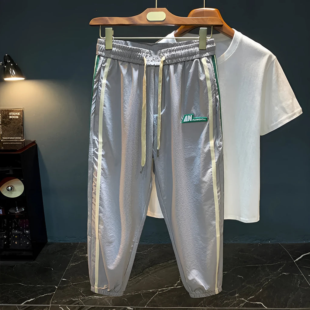 Man wearing solid black ice silk cotton harem pants with a mid waist and full trouser length.