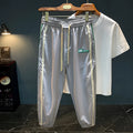 Man wearing solid black ice silk cotton harem pants with a mid waist and full trouser length.