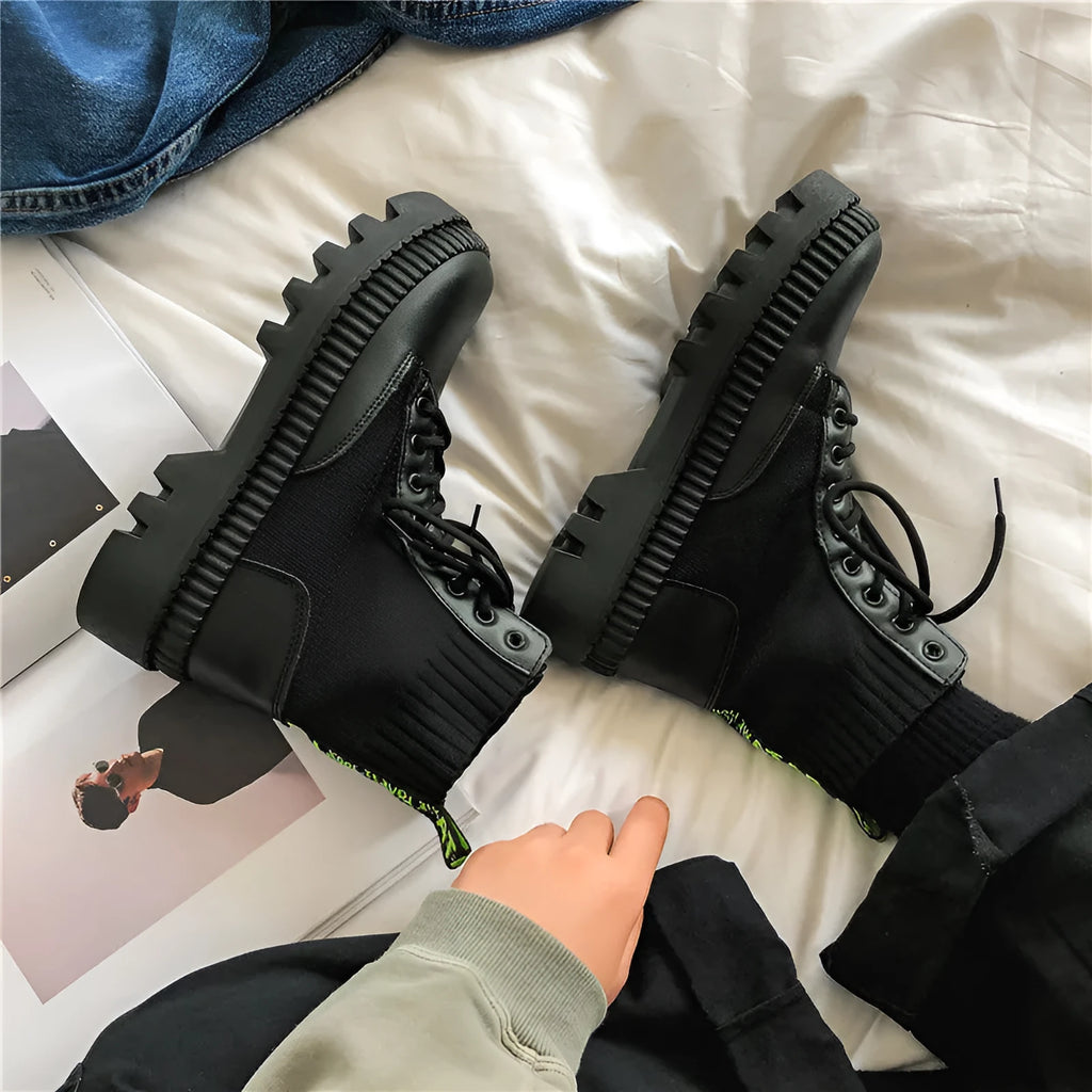 Men's smooth black leather Doc Martens platform boots with side zipper and chunky sole.