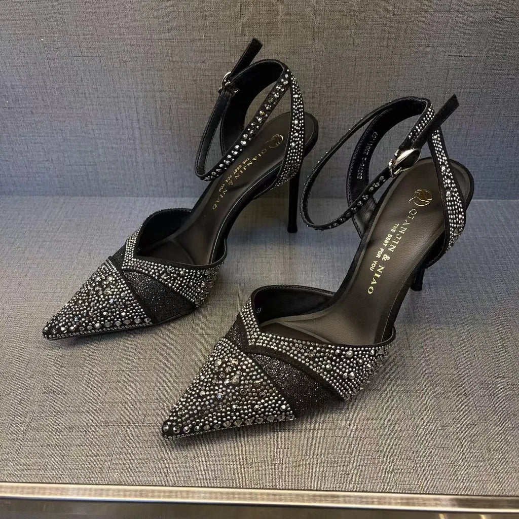 Women's black high heels with hollow stiletto heel, pointed toe, and a bright red sole.