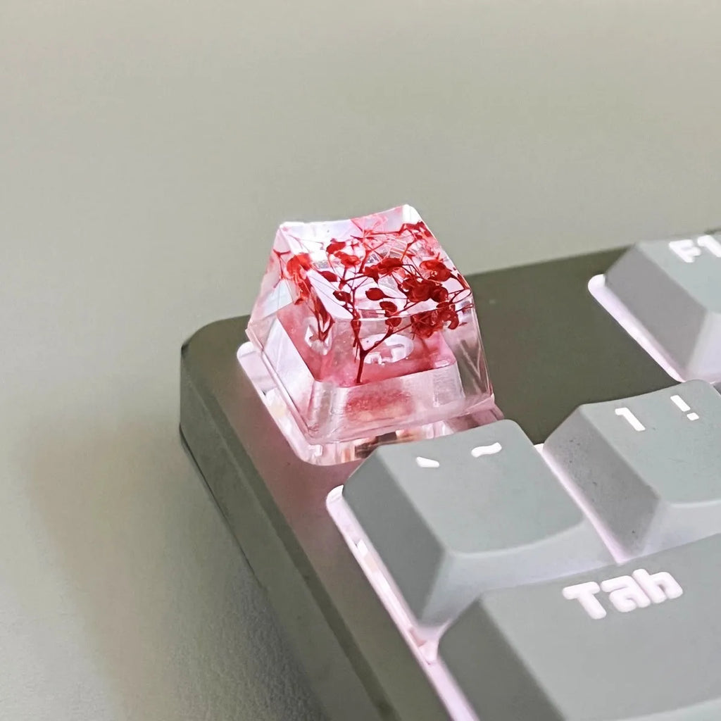 Transparent resin mechanical keyboard keycap with starry sky design in green, pink, red, violet colours.