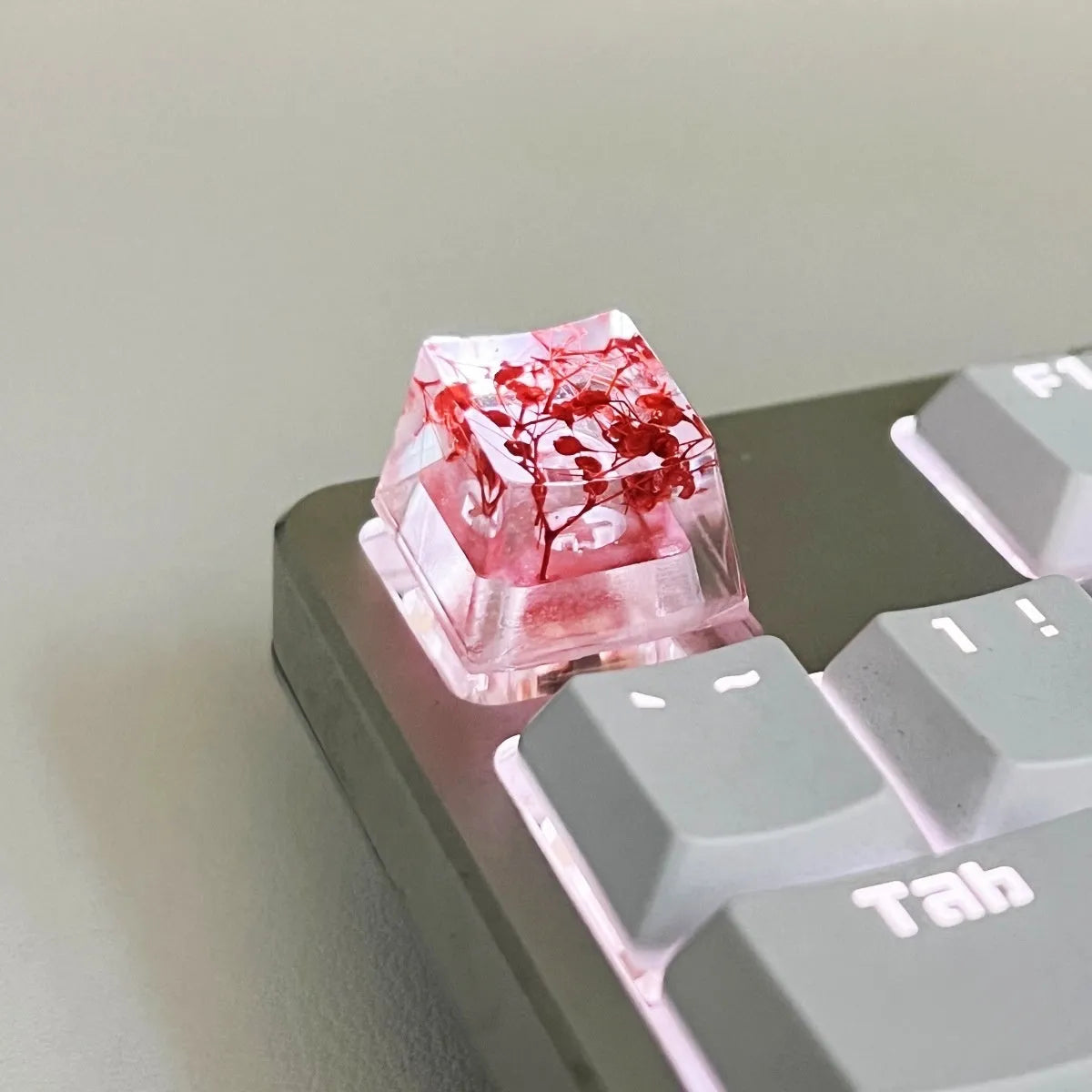 Transparent resin mechanical keyboard keycap with starry sky design in green, pink, red, violet colours.