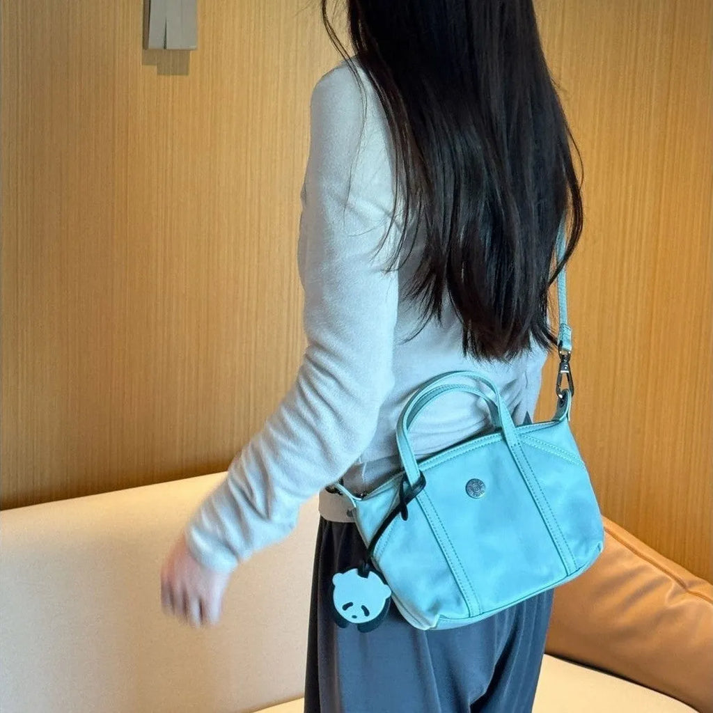 Casual lightweight nylon crossbody bag in dumpling shape, available colours black brown orange pink yellow, with pendant