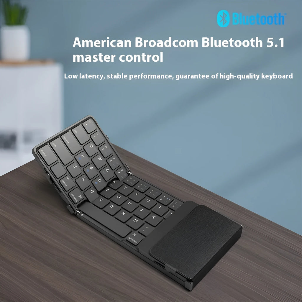 Black folding Bluetooth keyboard shown in open position next to mobile phone