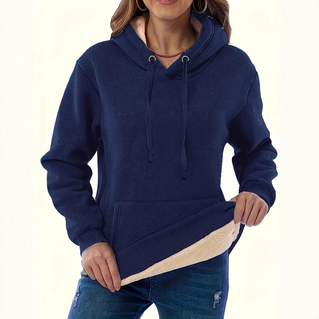 Woman wearing a thick grey hooded sweater with a 3D pattern and front pockets