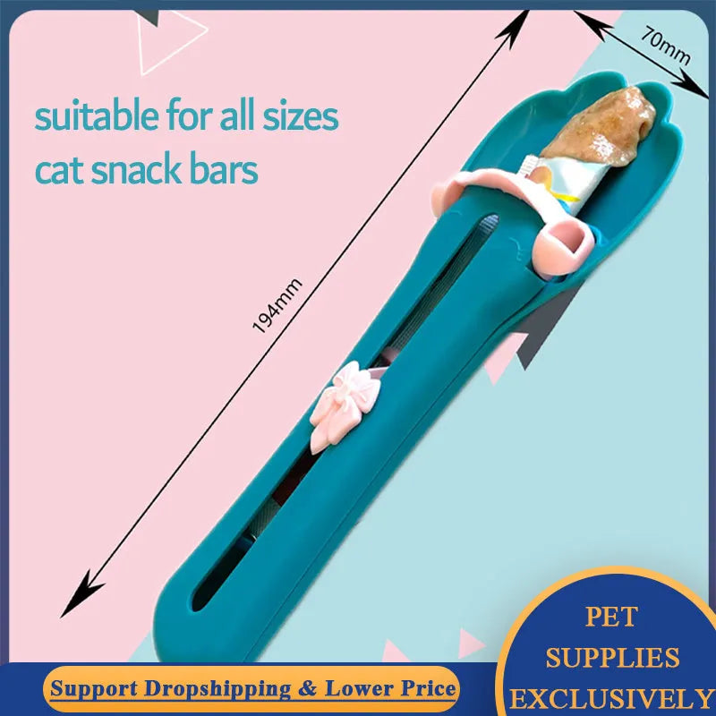 Green and pink plastic pet food squeezer feeder with a spoon-shaped dispensing end.