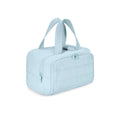 Large beige travel toiletry bag with wide open top, shown next to cosmetic bottles.