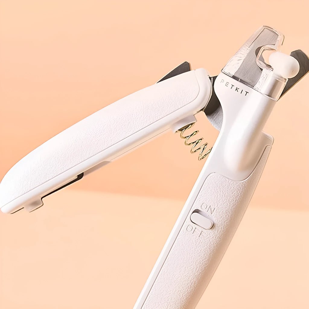 White pet nail clippers with LED light, transparent anti-splash guard, and leather-like handle on a table