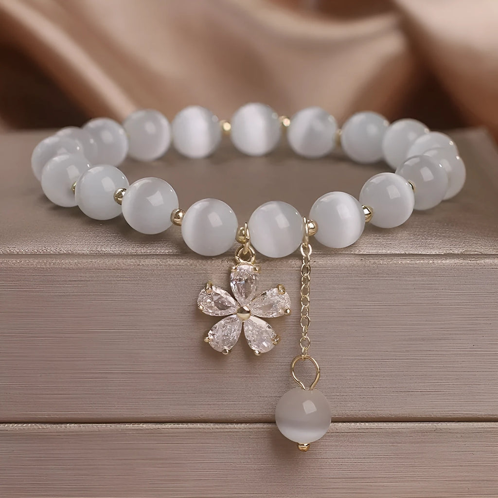 Single loop white cat's eye crystal bracelet with flower tassel and morganite safety buckle for women.