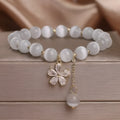 Single loop white cat's eye crystal bracelet with flower tassel and morganite safety buckle for women.