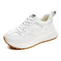 Women's beige low-top lace-up sports shoes made from cattlehide leather with a cross strap detail.