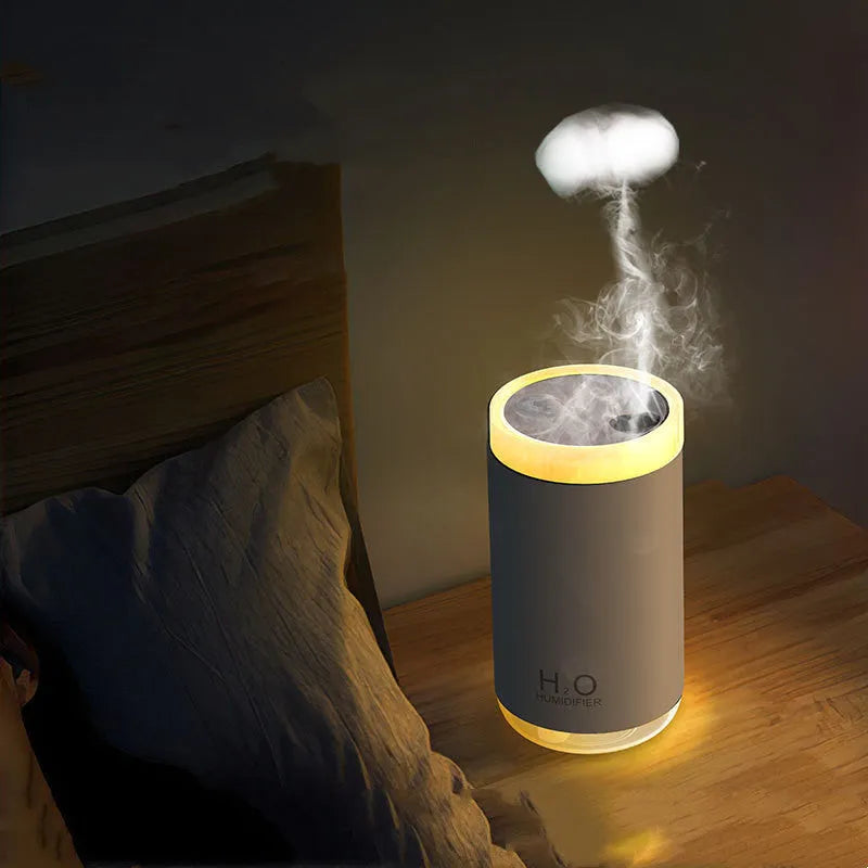 White jellyfish USB humidifier with night light on wooden surface showing mist output
