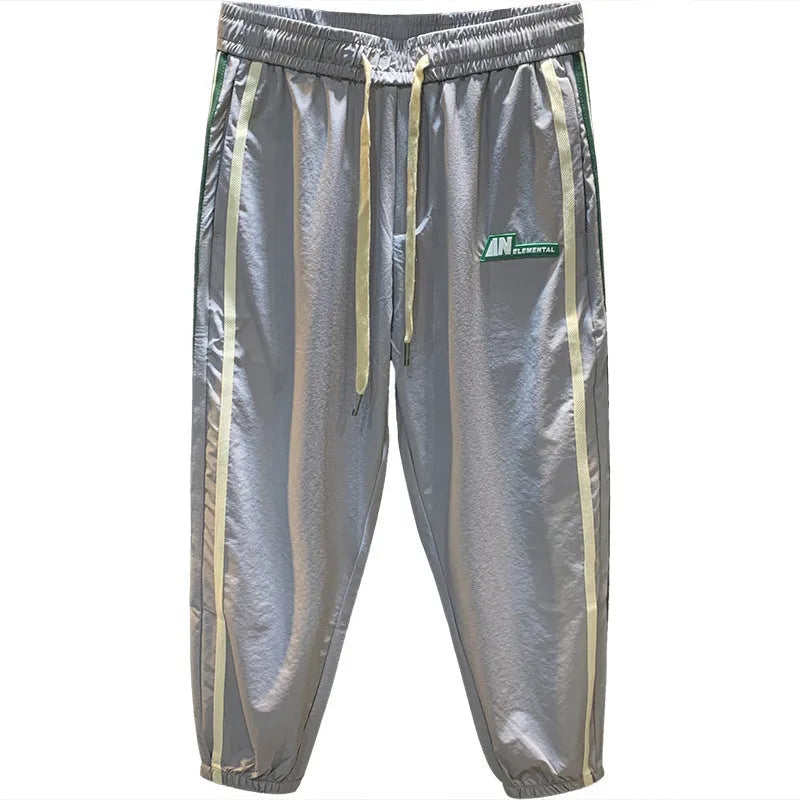 Man wearing solid black ice silk cotton harem pants with a mid waist and full trouser length.