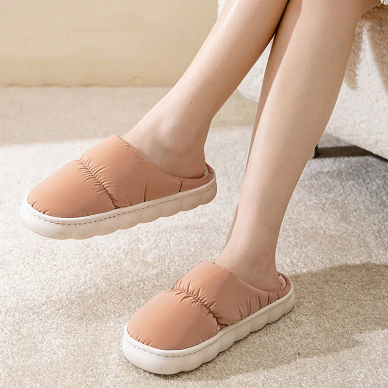 Pair of down cotton winter slippers with artificial leather upper, plush lining, and thick rubber sole.