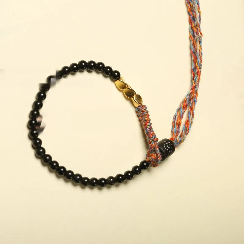 Hand-woven obsidian-coloured strap bracelet showing textured surface and slim 4mm width