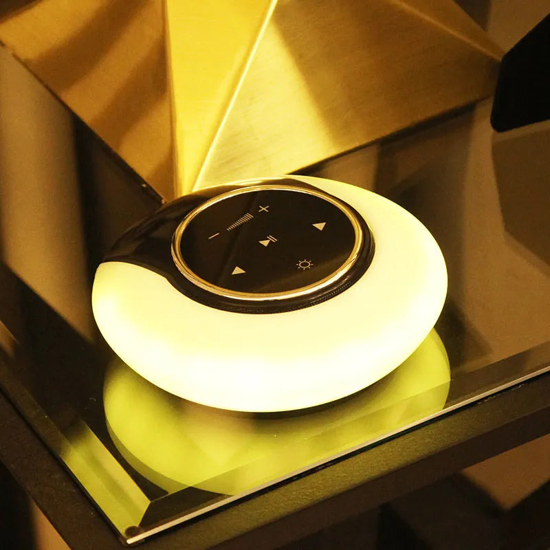 Creative folding Bluetooth speaker and LED desk lamp with touch controls on a desk.