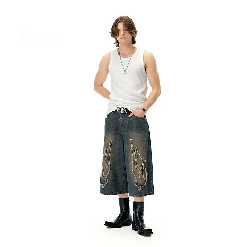 Men's black denim shorts with flame embroidery patch and straight leg cropped cut
